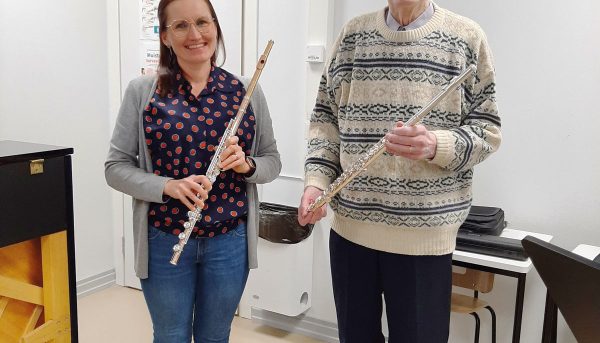 Tapio Knuuttila opiskelee huilun soittoa Emilia Alhon opastuksessa.